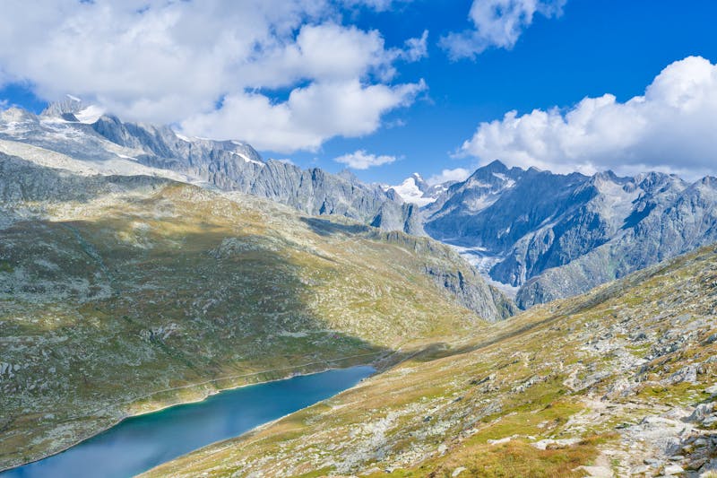 Mariés posant devant un panorama alpin avec sommets enneigés en arrière-plan