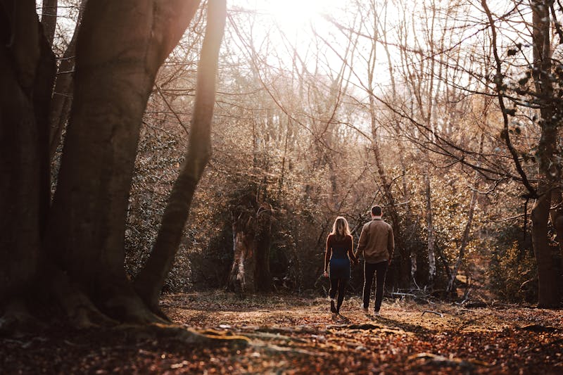 Couple souriant lors d'une séance photo engagement en pleine nature